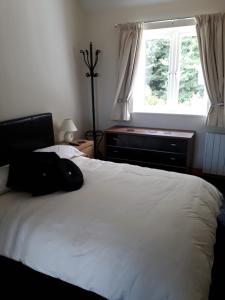 una camera da letto con un grande letto bianco e una finestra di The Grove, Grove Road Ryde Po333lh a Ryde