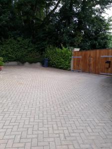 a brick driveway with a wooden fence and a wooden gate at The Grove, Grove Road Ryde Po333lh in Ryde