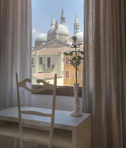 una silla y un jarrón delante de una ventana en Art Hotel Al Fagiano, en Padua