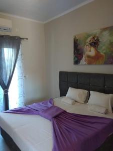 1 cama en un dormitorio con una pintura en la pared en Venus Sea View Apartment, en Perivólion