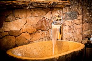 a sink in a stone bathroom with a water fountain at Hotel Tejera del Nalon in Soto del Barco +38 photos
