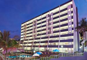 - un grand bâtiment avec une piscine en face dans l'établissement First Group Margate Sands, à Margate
