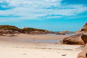 a sandy beach with a house on a hill at Hillcrest House Holiday Suites in Donegal