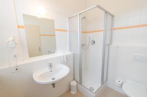 a bathroom with a shower, sink, and toilet at JUFA Hotel Meersburg am Bodensee in Meersburg