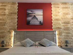 タラスコン・シュル・アリエージュにあるオテル テラノストラの赤い壁のベッドルーム1室