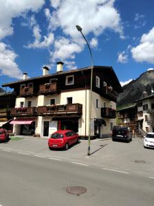 a red car is parked in front of a building at Mery Livigno in Livigno