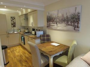 a kitchen with a wooden table and a dining room at Apartment 2 in Darlington