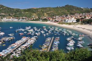 um monte de barcos ancorados numa praia em Pousada Estalagem do Porto em Arraial do Cabo