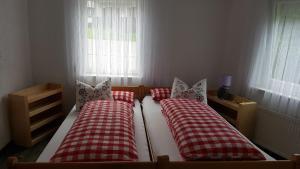 um quarto com 2 camas com almofadas vermelhas e brancas em Ferienwohnung Dilara em Immenstadt im Allgäu