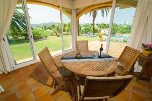 ein Esszimmer mit einem Holztisch und Stühlen in der Unterkunft Villa Cantallops in Jávea