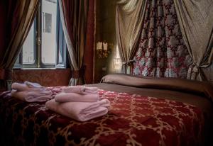 a bedroom with two beds with towels on the bed at Antica Dimora Delle Cinque Lune in Rome