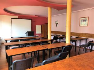 a classroom with wooden tables and chairs and a whiteboard at Hotel La Roka in Stara Zagora