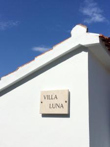 una señal en un lado de un edificio blanco en Villa Luna en Ražanj