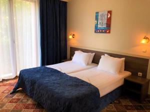 ein Schlafzimmer mit einem großen Bett mit einer blauen Decke in der Unterkunft Hotel La Roka in Stara Sagora