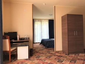 a bedroom with a bed and a desk with a computer at Hotel La Roka in Stara Zagora