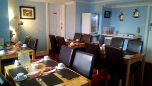 a dining room with wooden tables and chairs at Maridon House in Oban