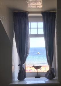 uma janela com vista para a praia em Tigh Na Mara Guest House Rosemarkie- breakfast optional em Rosemarkie