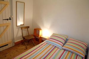 マルシアックにあるLa Maison WOAN centre de Marciacのベッドルーム1室(ベッド1台、椅子、テーブル付)