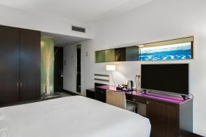 a hotel room with a bed and a tv at Vincci Maritimo in Barcelona