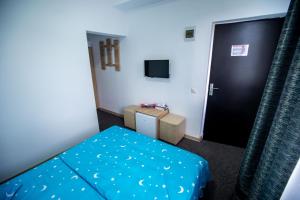 a small room with a bed and a door at Pensiune Perla - Bistrița Năsăud in Susenii Bîrgăului