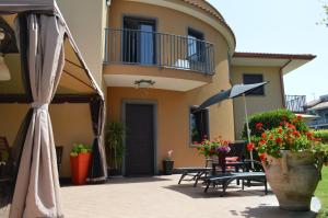 a house with a balcony and a patio with flowers at La Reggia dell'Etna in Zafferana Etnea