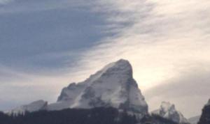 una montaña cubierta de nubes en el cielo en Alpenpension Auengrund, en Ramsau