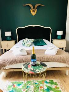 Un dormitorio con una cama y una mesa con una botella. en Appartement vue sur mer île de ré, en Rivedoux-Plage
