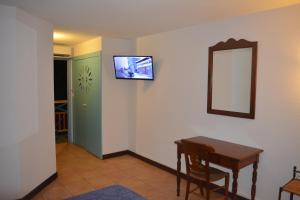 Habitación con mesa y espejo en la pared. en Appartement Mathena en Caritan