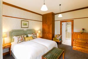 a bedroom with a large white bed and a desk at Eendracht Hotel in Stellenbosch +81 photos