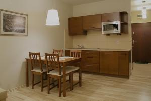 a kitchen with a table and chairs and a microwave at Apartamenty Junior in Wrocław