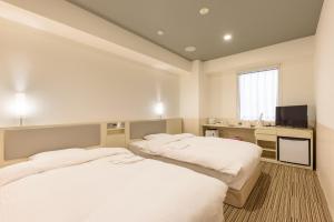 東京にあるベルケンホテル・神田のデスク、テレビが備わる客室のベッド2台