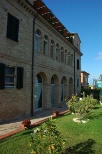 a large brick building with a yard in front of it at Agriturismo Casa degli Archi in Lapedona