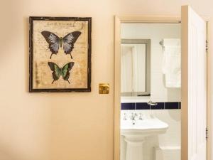 a bathroom with a picture of butterflies on the wall at Fielding Hotel in London