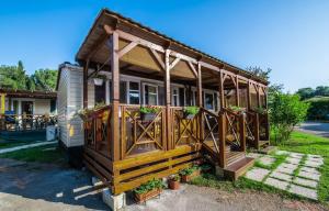 a tiny house with a porch with flowers on it at Camping Media Mobile Homes in Brioni Sunny Camping in Pula