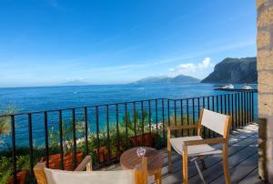 Un balcón con sillas y vistas al océano. en J.K. Place Capri en Capri