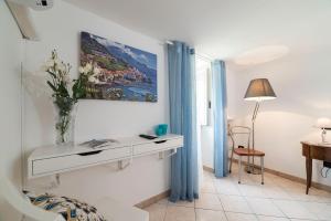 una stanza bianca con tavolo e vaso di fiori di Casa Taiani Amalfi Coast a Vietri