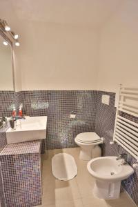 uma casa de banho com um WC branco e um lavatório. em ARGENTARIO Laura's POOL VILLA em Porto Ercole
