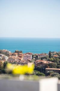 a view of a town with the ocean in the background at ARGENTARIO Laura's POOL VILLA in Porto Ercole
