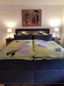 a bedroom with a bed with blue sheets and two lamps at Lindes Ferienwohnung in Dinkelsbühl