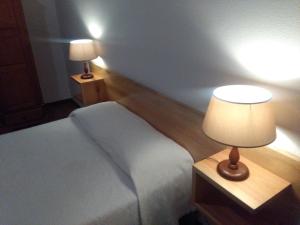 een slaapkamer met een bed en een tafel met een lamp bij AL Moniz in Machico