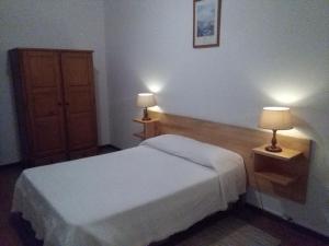 a hotel room with two beds and a lamp at AL Moniz in Machico