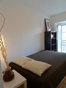 a bedroom with a bed and a lamp on a table at Jardin d'Olisipo - Centre Ville in Lisbon