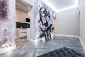 uma sala de estar com uma mesa e um quadro na parede em LuMa Suite Via Veneto - Your luxury style 22 em Roma