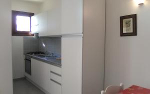 ブドーニにあるLa Coccinellaの小さなキッチン(白いキャビネット付)、窓