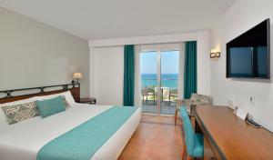 1 dormitorio con cama, escritorio y vistas al océano en Sol Torremolinos - Don Marco Adults Recommended, en Torremolinos