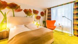 ein Schlafzimmer mit einem Bett und einem Fenster mit Blumen an der Wand in der Unterkunft Wellings Parkhotel in Kamp-Lintfort