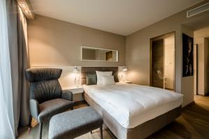 a hotel room with a bed and a chair at Wellings Parkhotel in Kamp-Lintfort