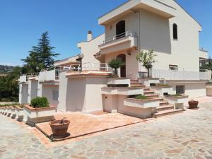 a large white house with stairs and potted plants at b&b le zagare in Caltanissetta