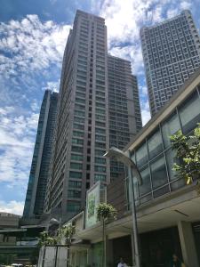 Un edificio alto con una statua di uccello davanti. di GREENFIELD studio w/ 2 queen across Shangrila a Manila