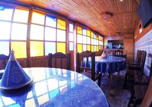 a dining room with two tables and windows at Riad Les Chtis D'Agadir in Agadir